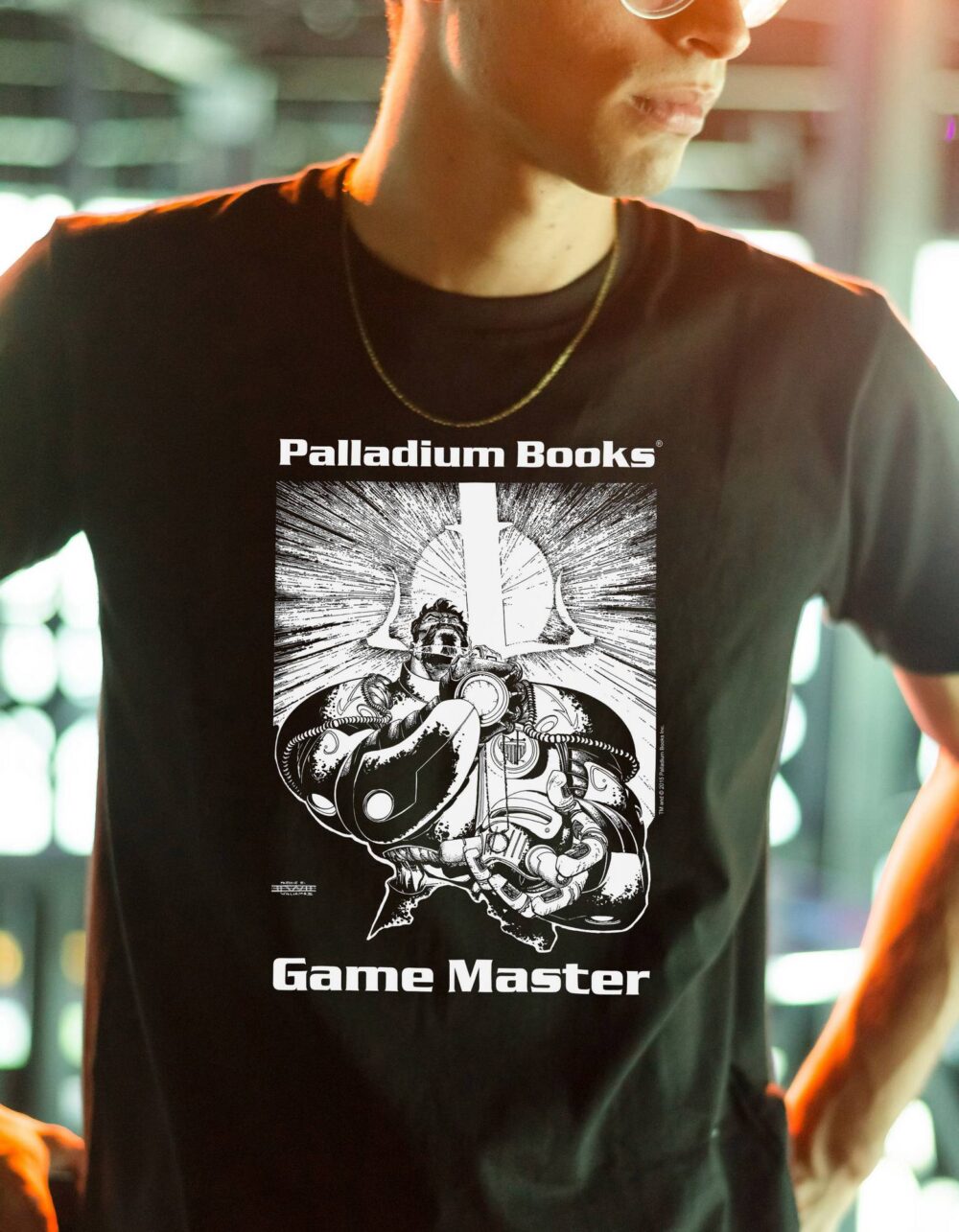 A black shirt with Palladium Books Game Master written in white on it and with a picture of the cyberknight Lord Coake holding his psi sword