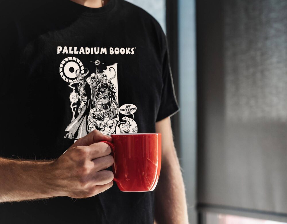 A black shirt with "Palladium Books open house 2018" written in white on it and a picture of the team from machinations of doom on it